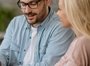 happy-man-his-wife-using-digital-tablet-while-being-meeting-with-bank-manager-office