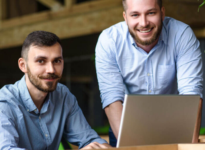 picture-handsome-businessman-listening-his-colleague-partner-concerning-ner-business-system-while-working-laptop-computer-office-interior